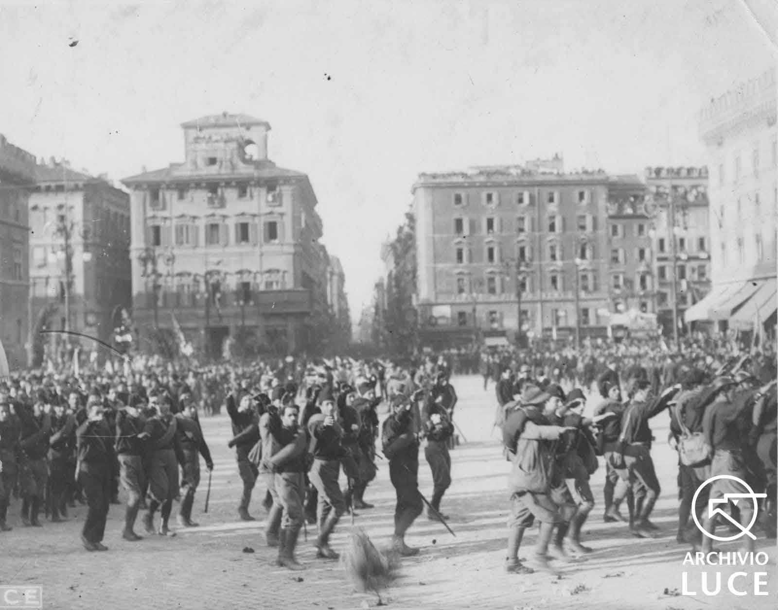 Marcia su Roma, le camicie nere sfilano in piazza Venezia sollevando il braccio nel saluto fascista